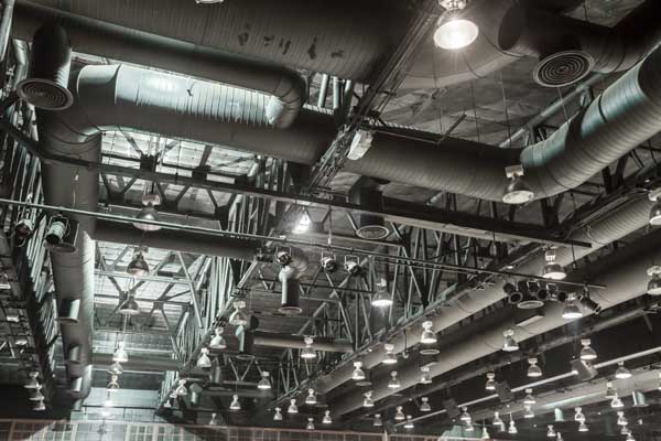 HVAC Duct Cleaning, Ventilation pipes in silver insulation material hanging from the ceiling inside new building
