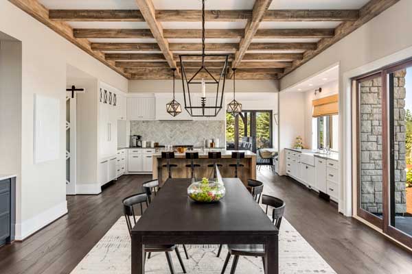 Stunning kitchen and dining room in new luxury home Wood beams and elegant pendant lights accent this beautiful open plan dining room and kitchen